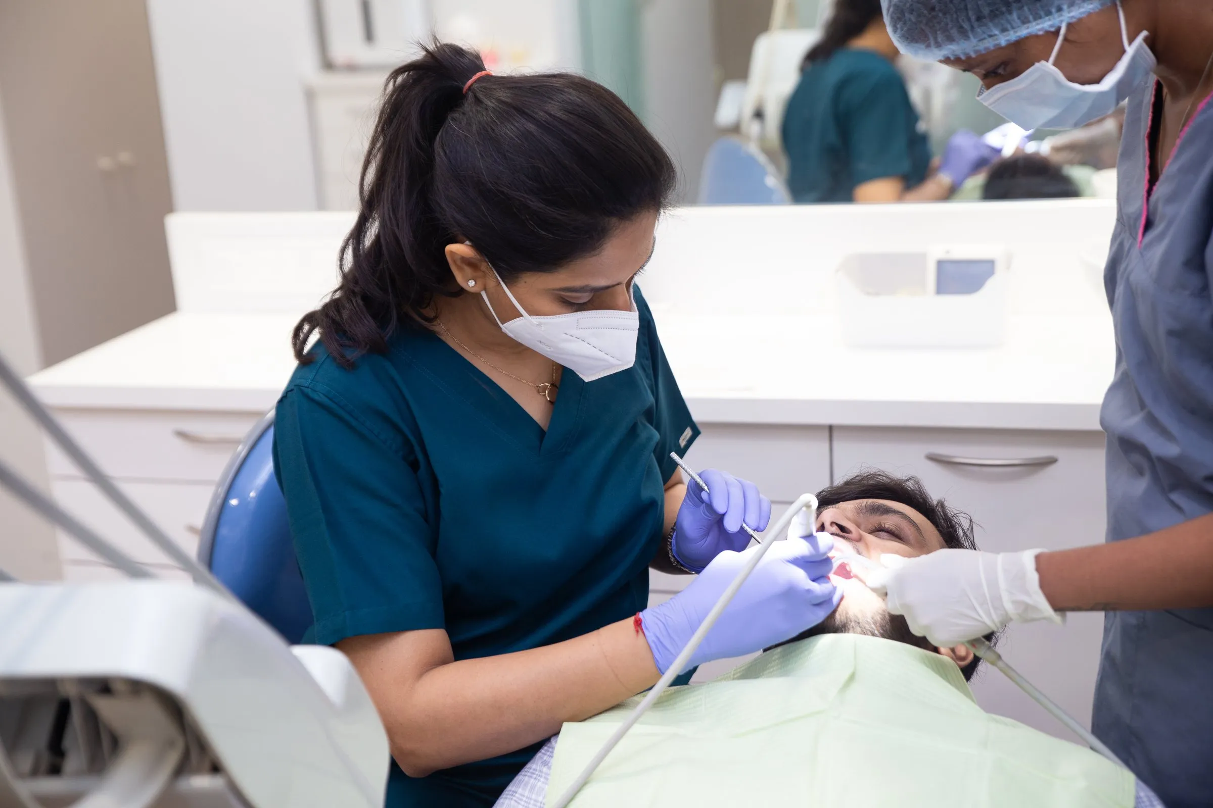 Dr. Upasana Gosalia treating a patient with an assistant at i-Smile Dental Clinic, Ghatkopar East